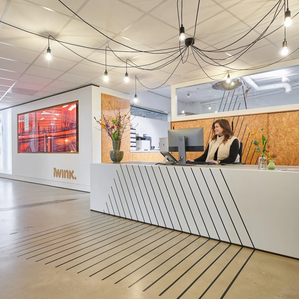 Moderne receptie met bureaumederwerker in een strak kantoorinterieur.