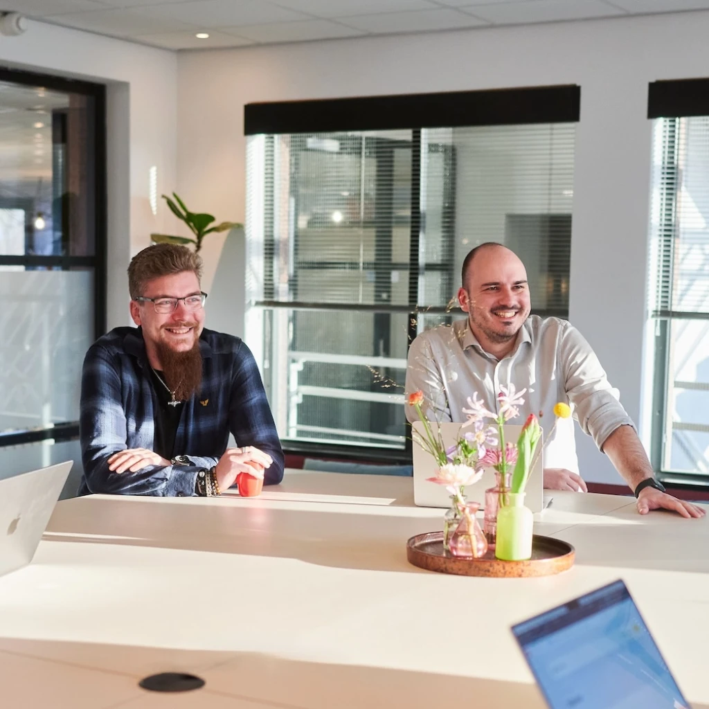 Mensen in een kantooromgeving tijdens een informele vergadering.
